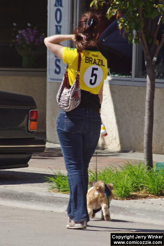 A fan of vintage cars walks her dog along the street.