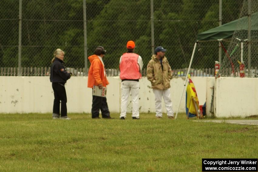 Corner workers at turn 12 watch cars at turn 6 on the pace lap