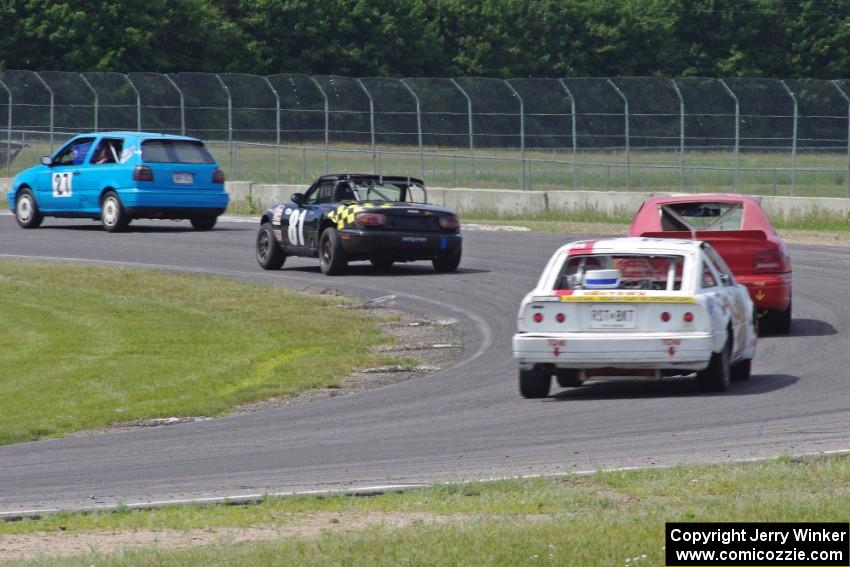 Four cars drive through turn 4