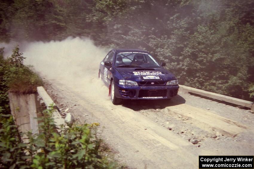 Bill Driegert / Claire Chizma Subaru WRX at speed over a bridge on SS5, Magalloway North.