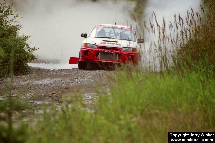 Garen Shrader / Doc Schrader Mitsubishi Lancer Evo IV splashes through a puddle on SS8, Parmachenee Long.