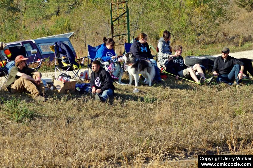 Folks sitting at the side of the course watching the action.