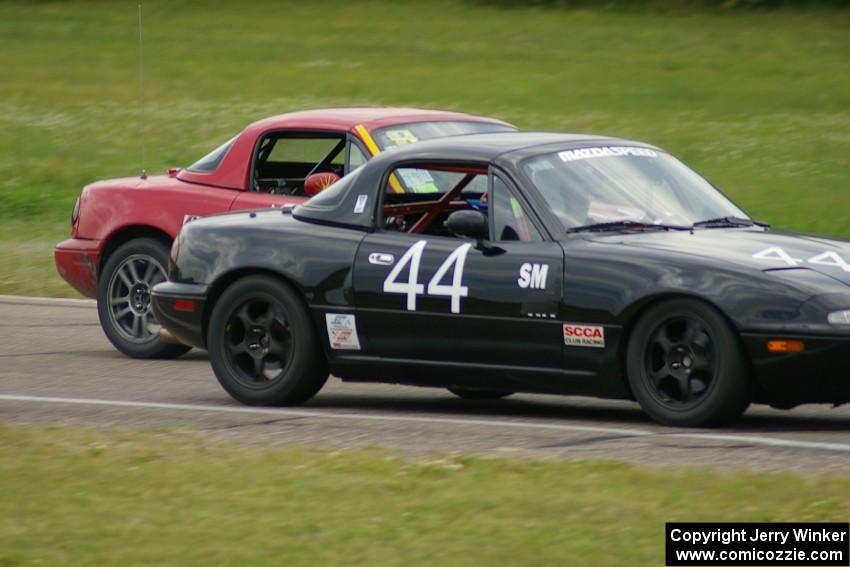 Greg Youngdahl ducks inside Paul Gilbert, both running Spec Miata Mazda Miatas.