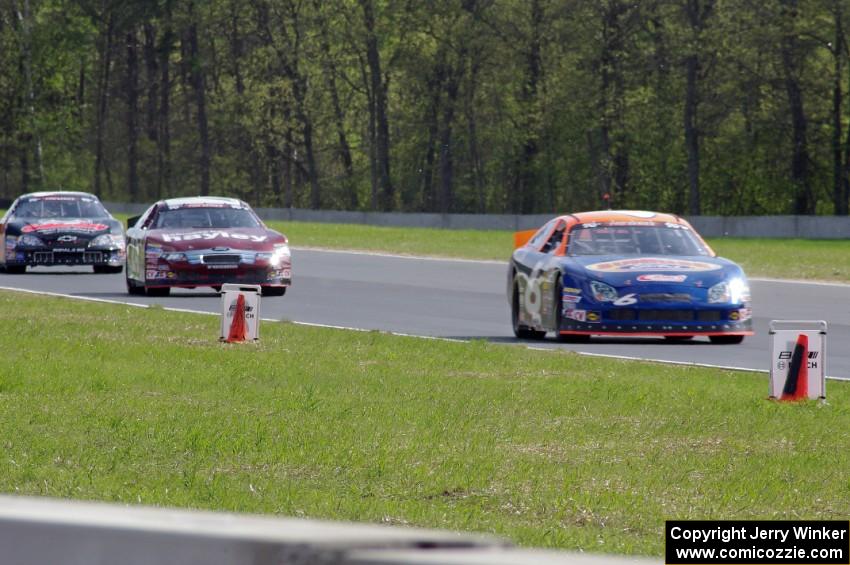 Derek Thorn's Ford Fusion ahead of Cameron Hayley's Ford Fusion and Michael Self's Chevy Impala.