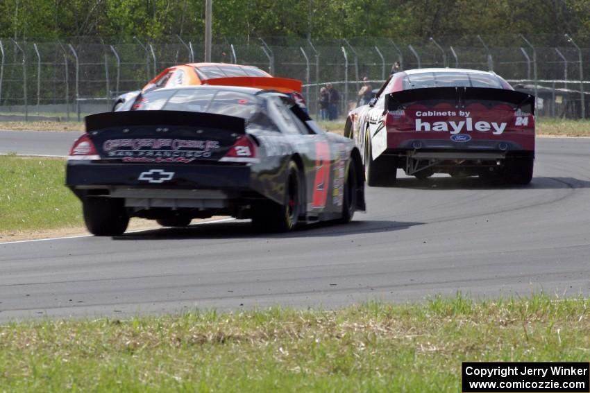 Derek Thorn's Ford Fusion ahead of Cameron Hayley's Ford Fusion and Michael Self's Chevy Impala.