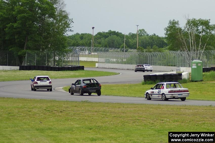 Five cars come out of the carousel and into the esses.