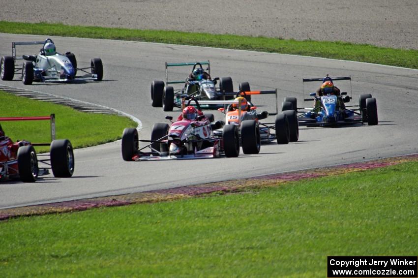 The field streams out of the carousel on lap one.