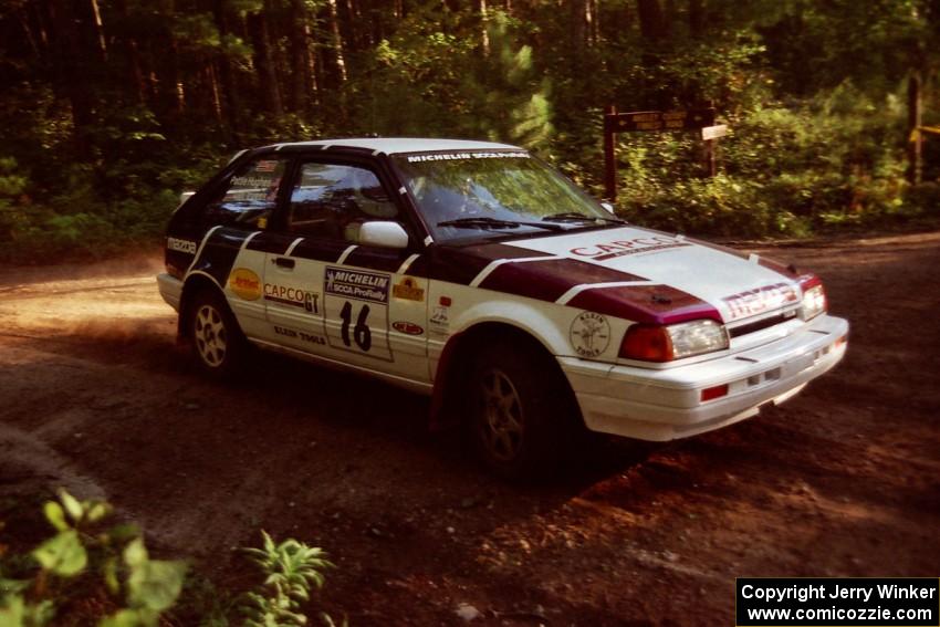 Gail Truess / Pattie Hughes Mazda 323GTX at a 90-right on SS1, Akeley Cutoff.