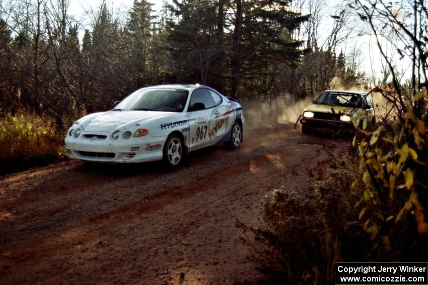 Art Burmeister / Bob Martin VW GTI passes the Perry King / Mark Williams Hyundai Tiburon near the end of SS17, Gratiot Lake II.