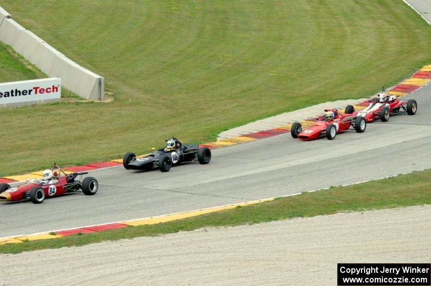 Four cars run nose-to-tail through turn 7.