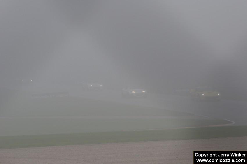 The second race starts under yellow flag conditions, behind the pace car, due to thick fog.