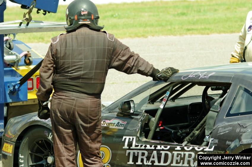 An exhausted John Atwell leans against his Chevy Camaro.