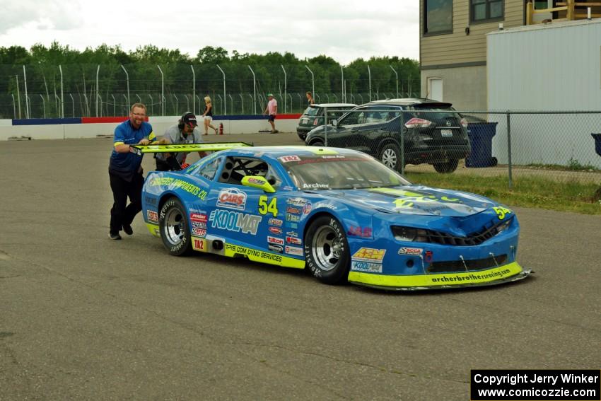 Tommy Archer's Chevy Camaro is pushed through the paddock after the race.