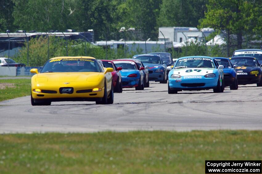 The Spec Miata and smaller production class field comes into turn 12 on the pace lap.