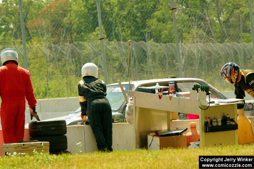 Chump Faces BMW 325is in the pits.