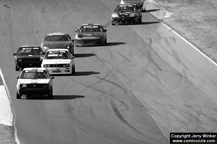 A group of cars streams between turns 5 and 6.