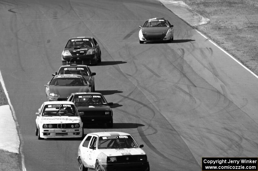 A group of cars streams between turns 5 and 6.