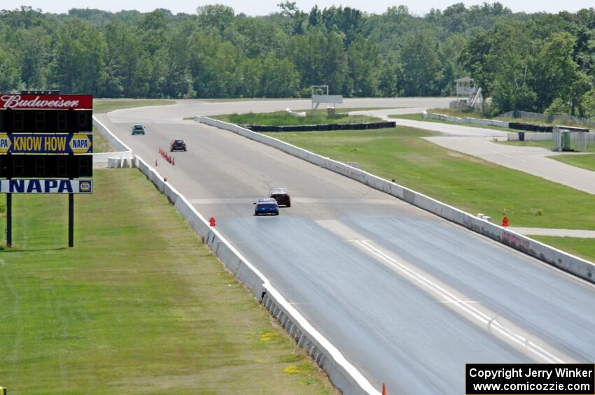 Four cars head down the front straight.