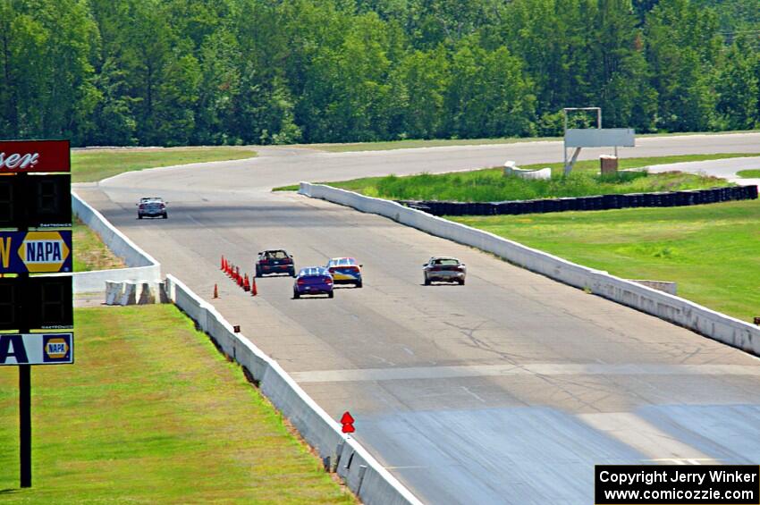 Five cars head down the front straight.