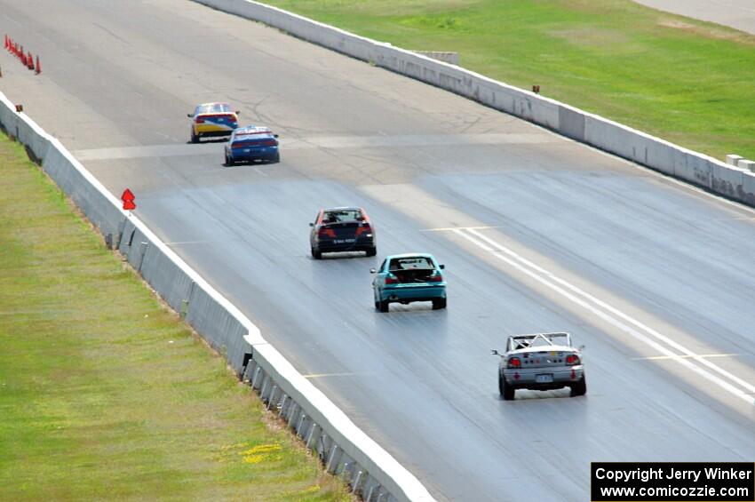 Five cars head down the front straight.