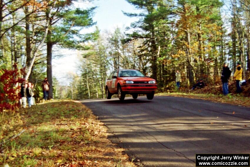 Gail Truess / Pam McGarvey Mazda 323GTX at the midpoint jump on SS16, Brockway Mt.