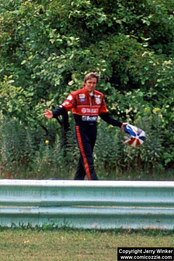 Eddie Cheever walks back to the pits and waves to the fans after DNF'ing.