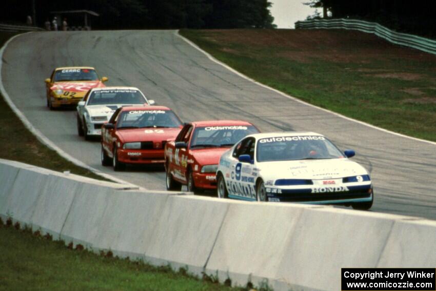 Five cars stream downhill into turn 5.