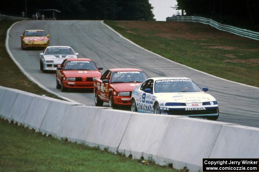 Five cars stream downhill into turn 5.