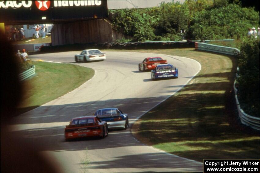 Five cars stream uphill toward turn 13.