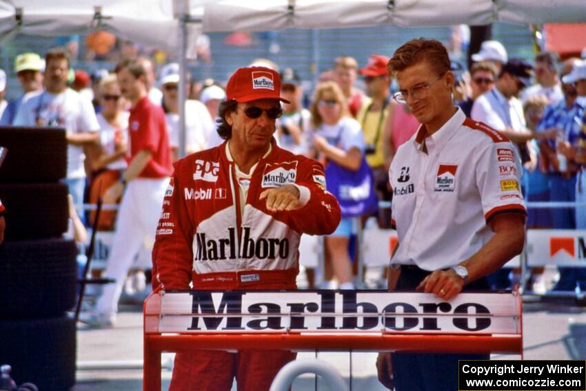 Emerson Fittipaldi and an aerodynamicist discuss setup in the paddock.