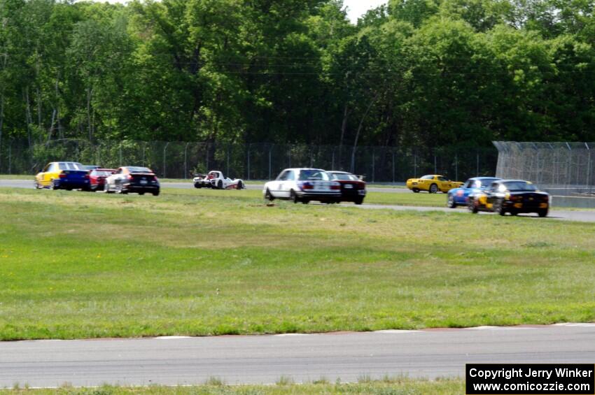 The field streams into turns four and  five on the pace lap.