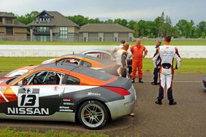 Patrick Price's and James Berlin's Nissan 350Zs, post-race, while others gather around.