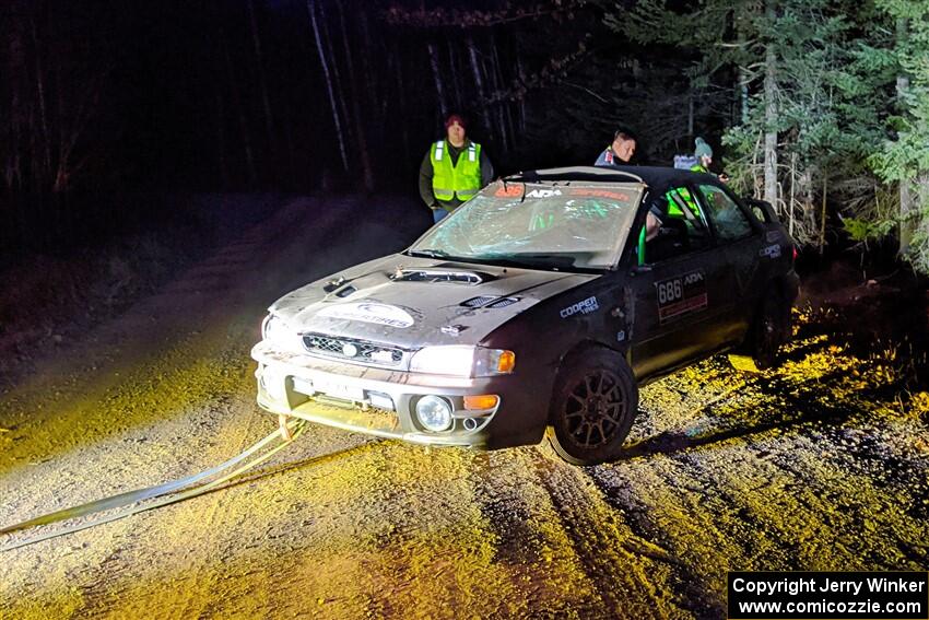 Jordan Locher / Tom Addison Subaru Impreza 2.5RS is pulled from the woods after rolling on SS1.