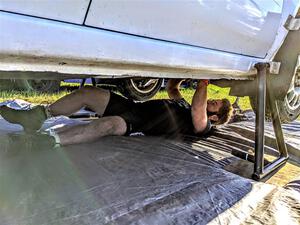 Kevin Dobrowolski underneath the team's Subaru Impreza 2.5i prior to the start of day two.