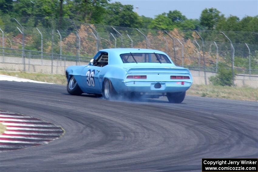 Scott Shadel's Chevy Camaro limps by with a broken suspension and flat tire.