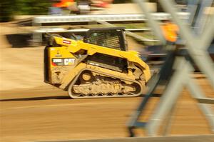 A small bulldozer helps smooth out the track surface.