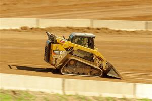 A small bulldozer helps smooth out the track surface.