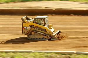 A small bulldozer helps smooth out the track surface.