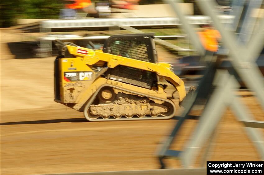 A small bulldozer helps smooth out the track surface.