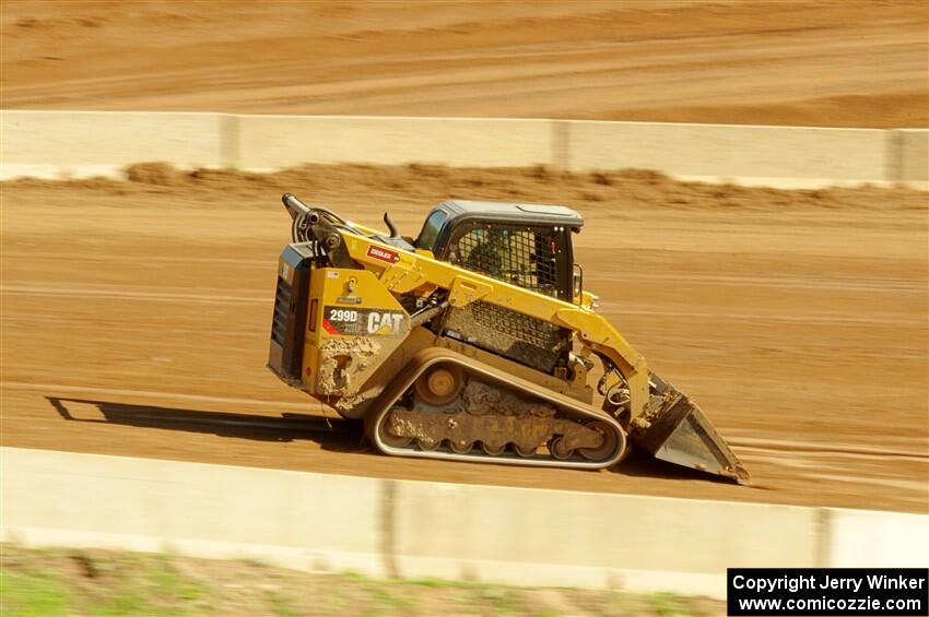 A small bulldozer helps smooth out the track surface.