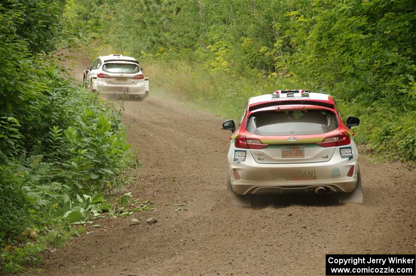 Allen Dobasu / Patrick Walsh Ford Fiesta passes the Lucy Block / Michelle Miller Ford Fiesta Rally3 on SS1, Crossroads I.