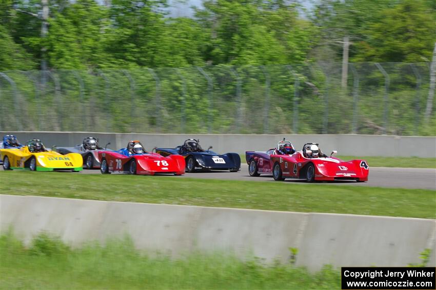 The Spec Racer Ford 3 field comes into turn 2.