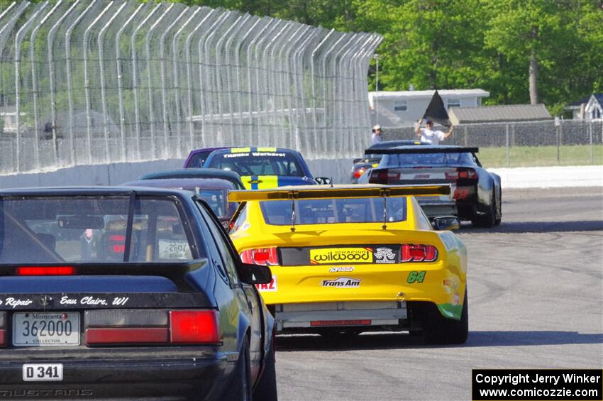 and Dan Little's American Sedan Ford Mustang head for the track exit.