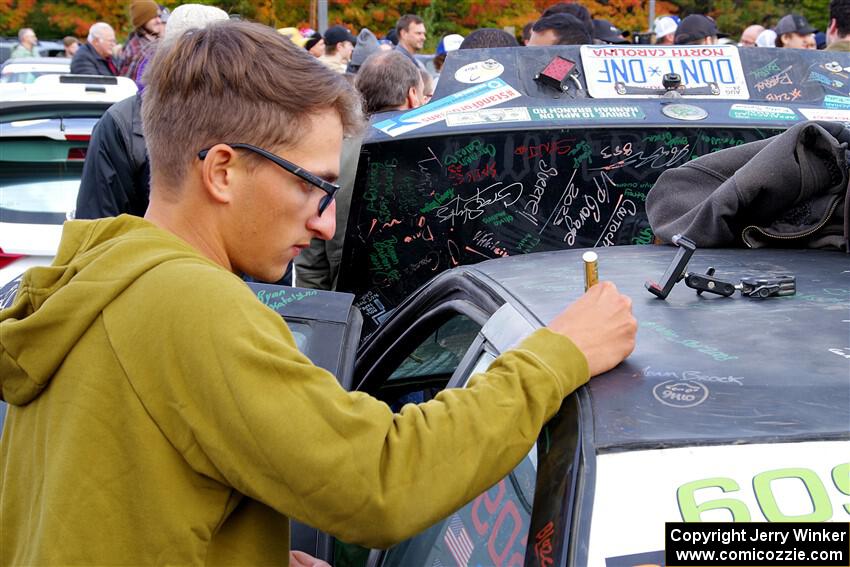 A fan adds his signature to the Keenan Phillips / Salina Melotti BMW 328i.