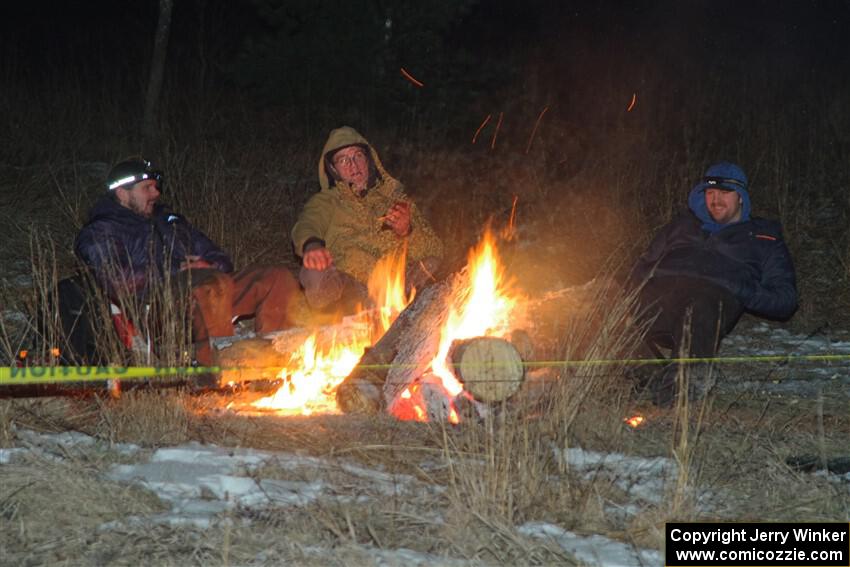 Marshals and workers keep warm by a campfire before SS15, Camp 30-East Branch II.