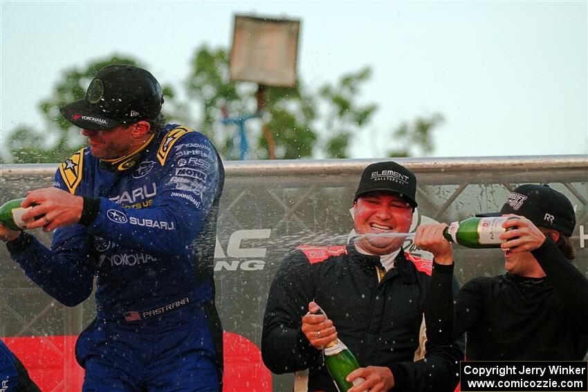 Javier Olivares and K.J. Miller spray champagne on Travis Pastrana on the winner's podium.