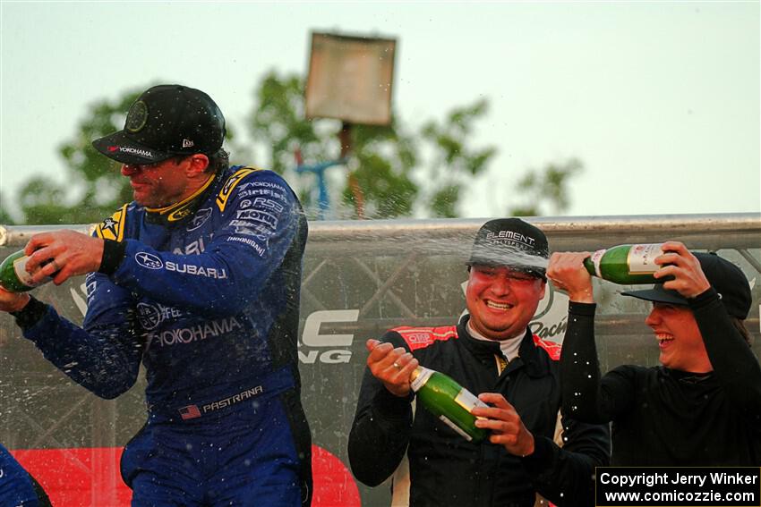 Javier Olivares and K.J. Miller spray champagne on Travis Pastrana on the winner's podium.