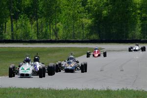 The vintage formula car field comes between turns three and four on lap one.