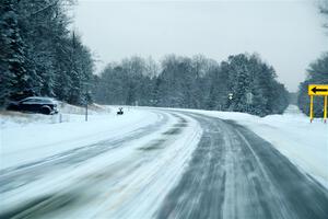 Falling snow blows over the road leaving Atlanta, MI.