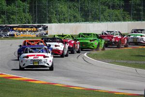 A train of Mazda MX-5 Cups head through the kink.